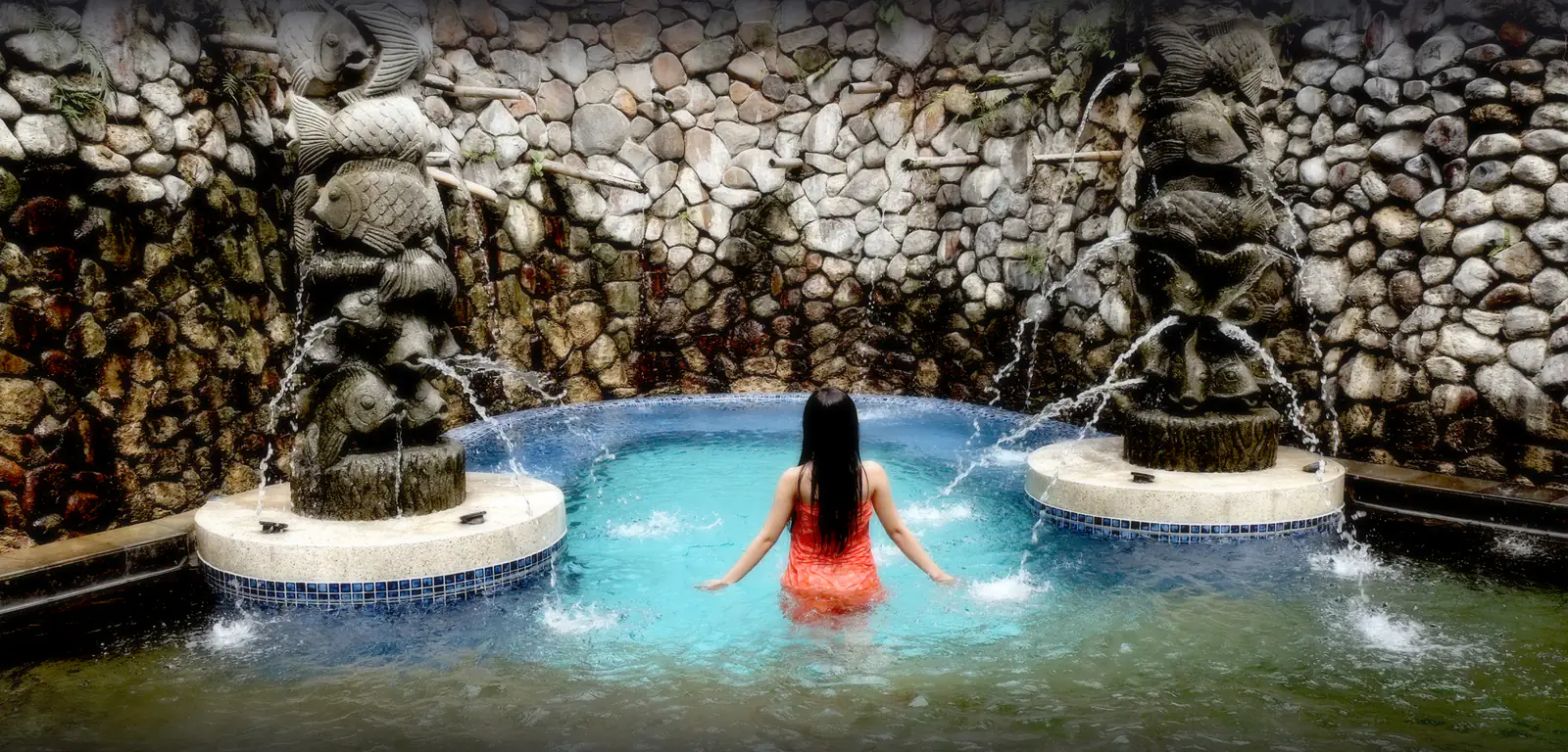 Kolam air panas berdinding batu menyerupai gua