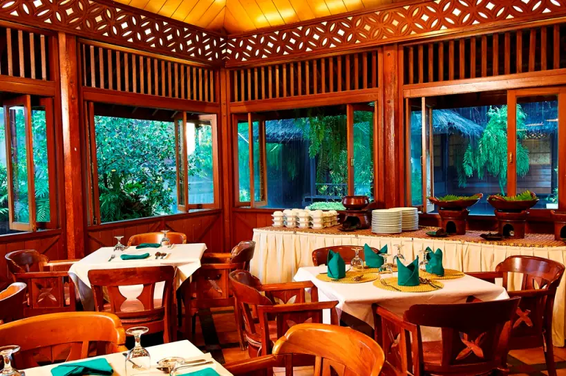 Ruang makan Tunjung Balebat berdinding kayu menghadap kolam