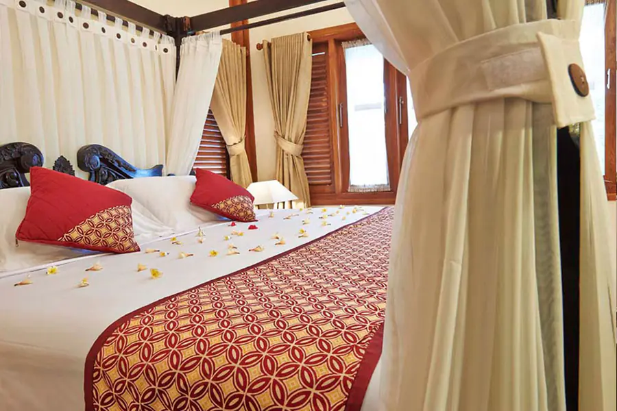Kamar suite dengan tempat tidur besar dan dinding kayu